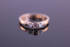 Three stone ring with rubover setting bezel set in rose gold